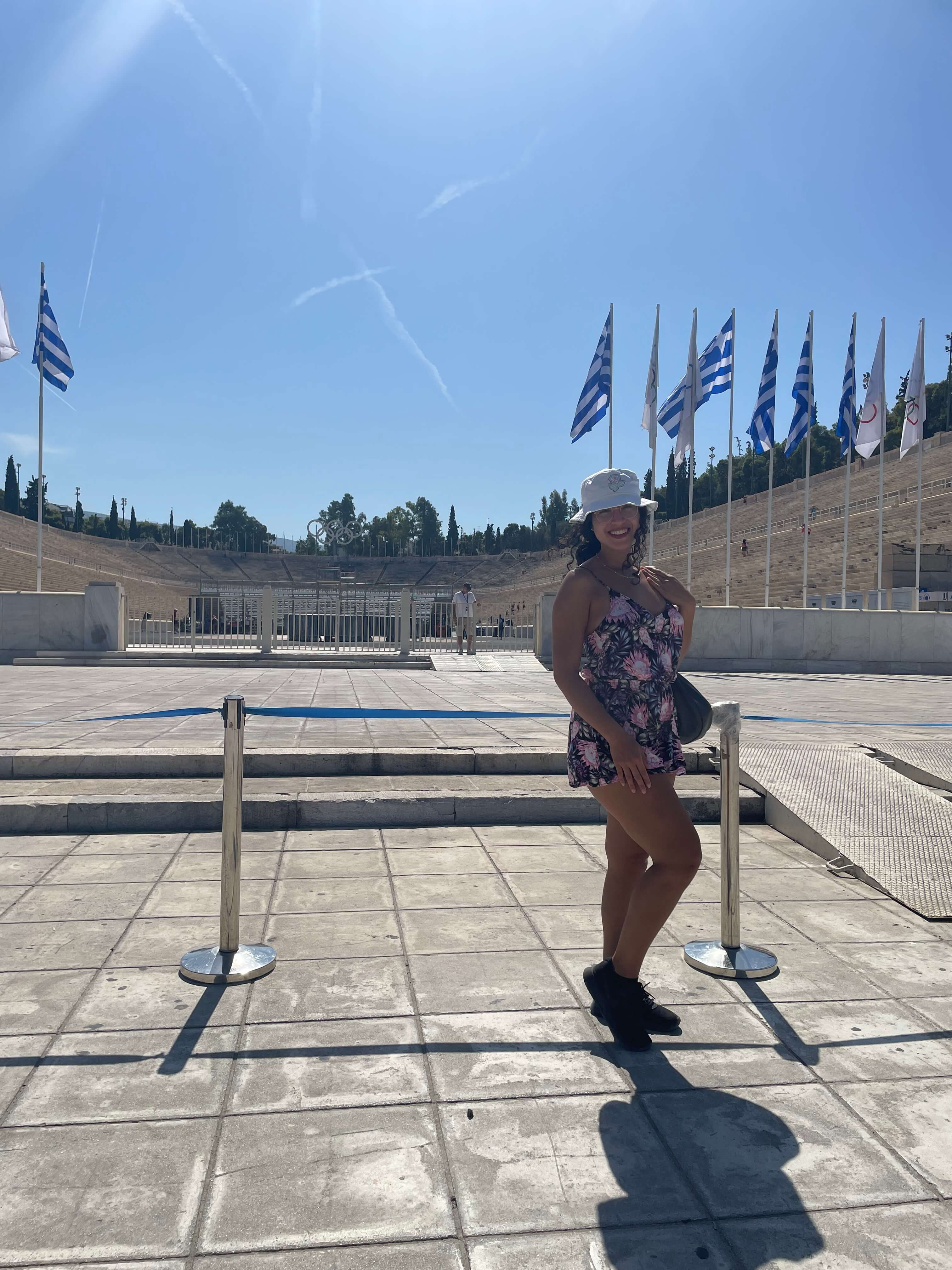 Me as a solo female traveler in Athens, Greece during a guided walking tour in the heat of summer while wearing a white bucket hat