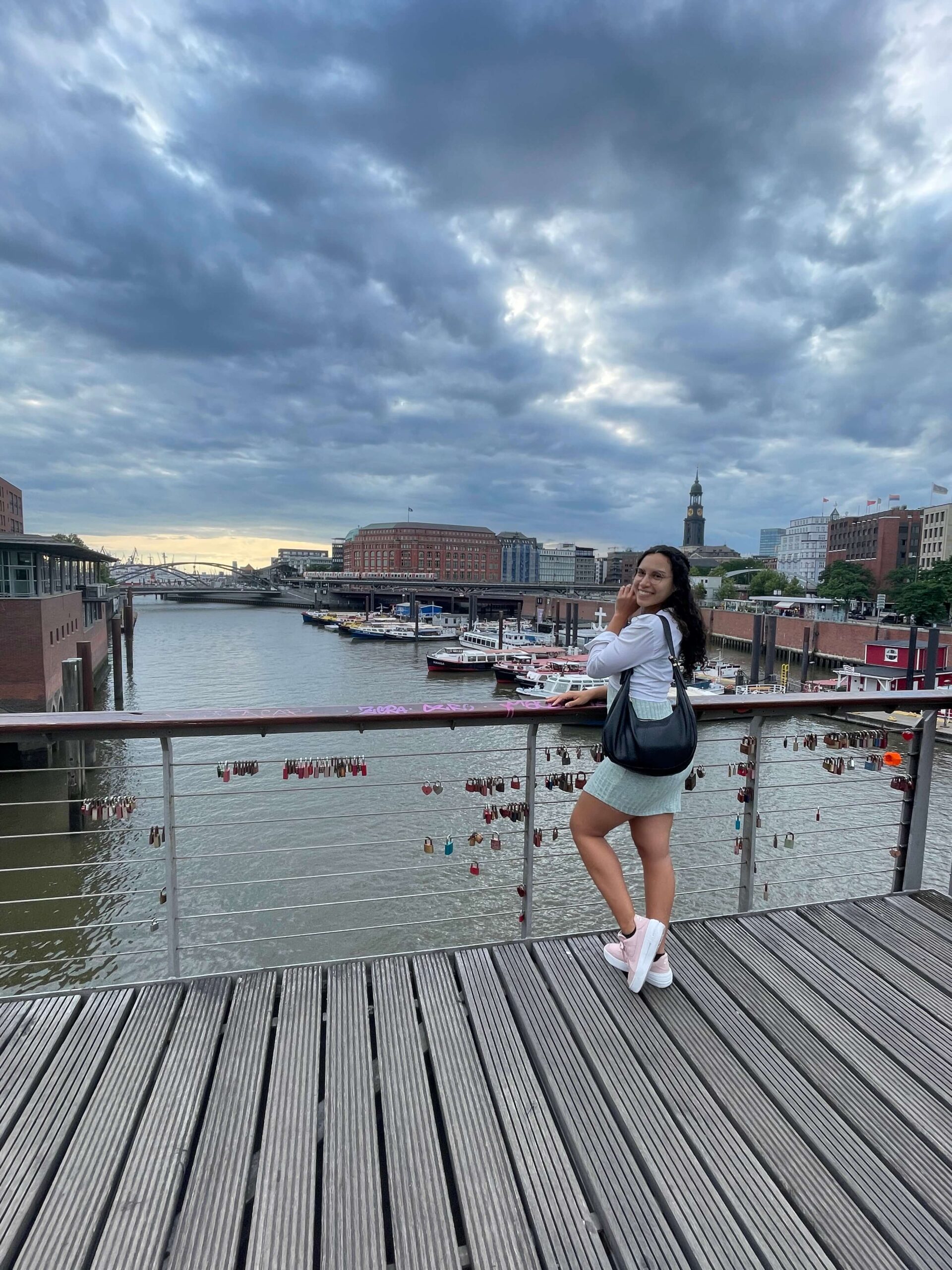 Me as a Solo Female Traveler in Hamburg, Germany with my black hobo purse, pink nike shoes and white button up shirt