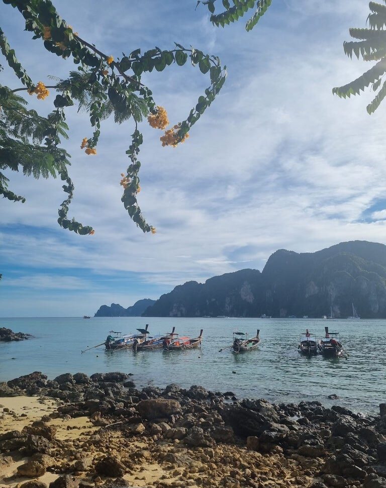 Long tail boats floating on crystal clear water of phi phi island thailand