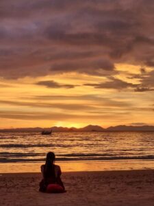 Solo female traveler enjoying the sunset on railay beach thailand