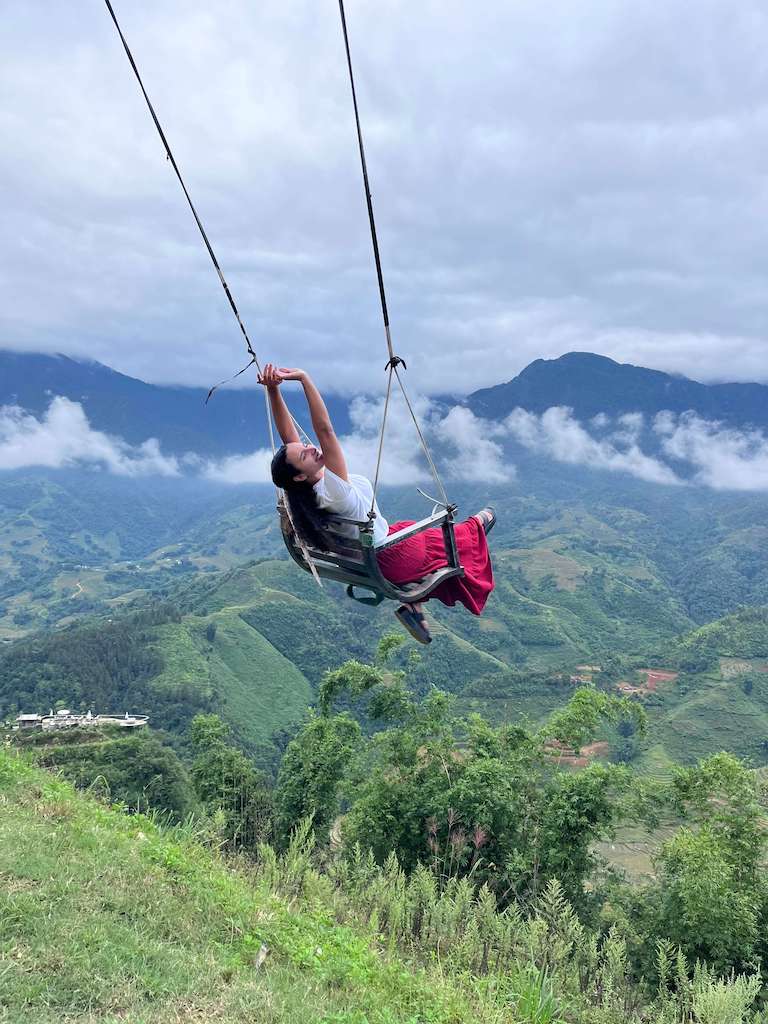 Solo female traveler on swing in Moana Sapa Vietnam on a mountain amongst the clouds during her Vietnam one month itinerary trip