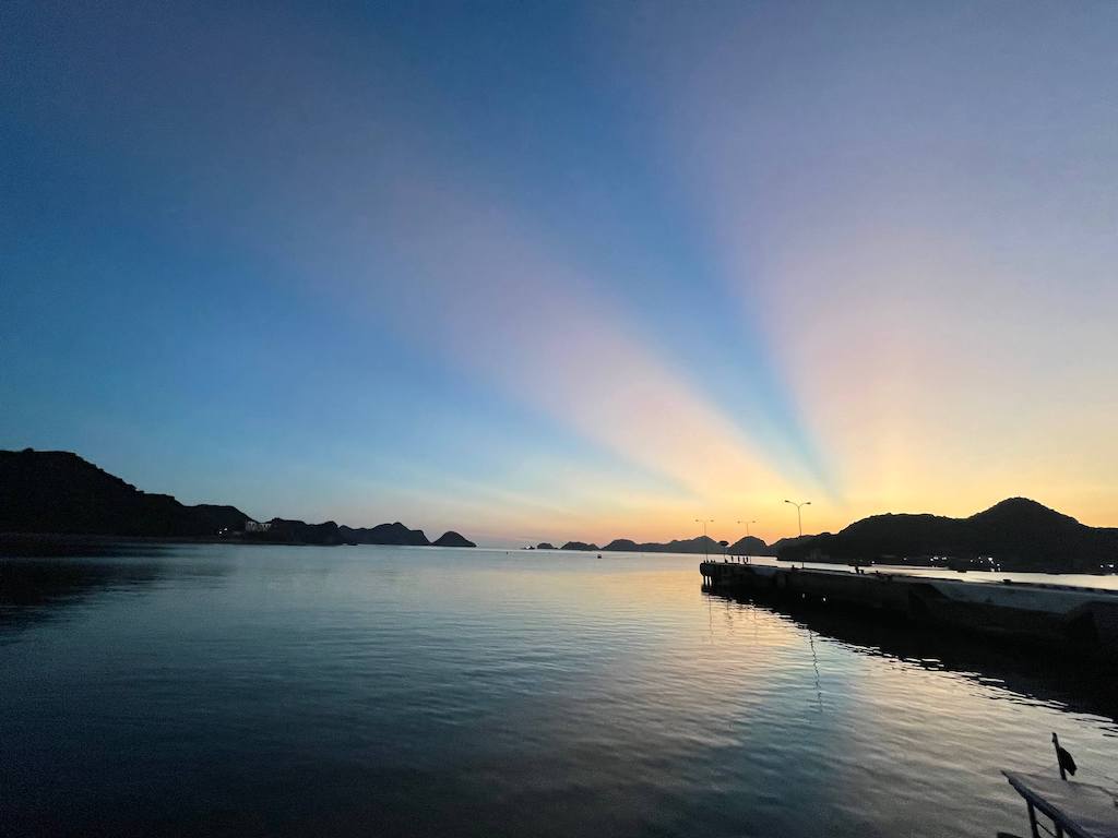 Sunset at Cat Ba Pier with pink, yellow and blues painting the sky